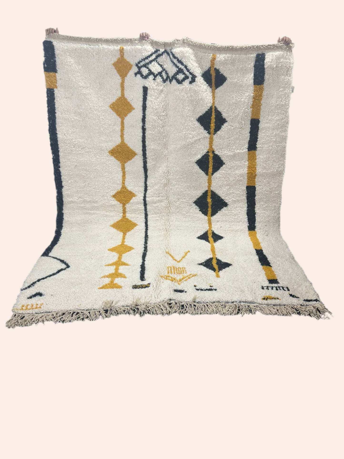 Amal is an off white Moroccan wool rug with black and mustard coloured lines and diamonds in the tribal design.