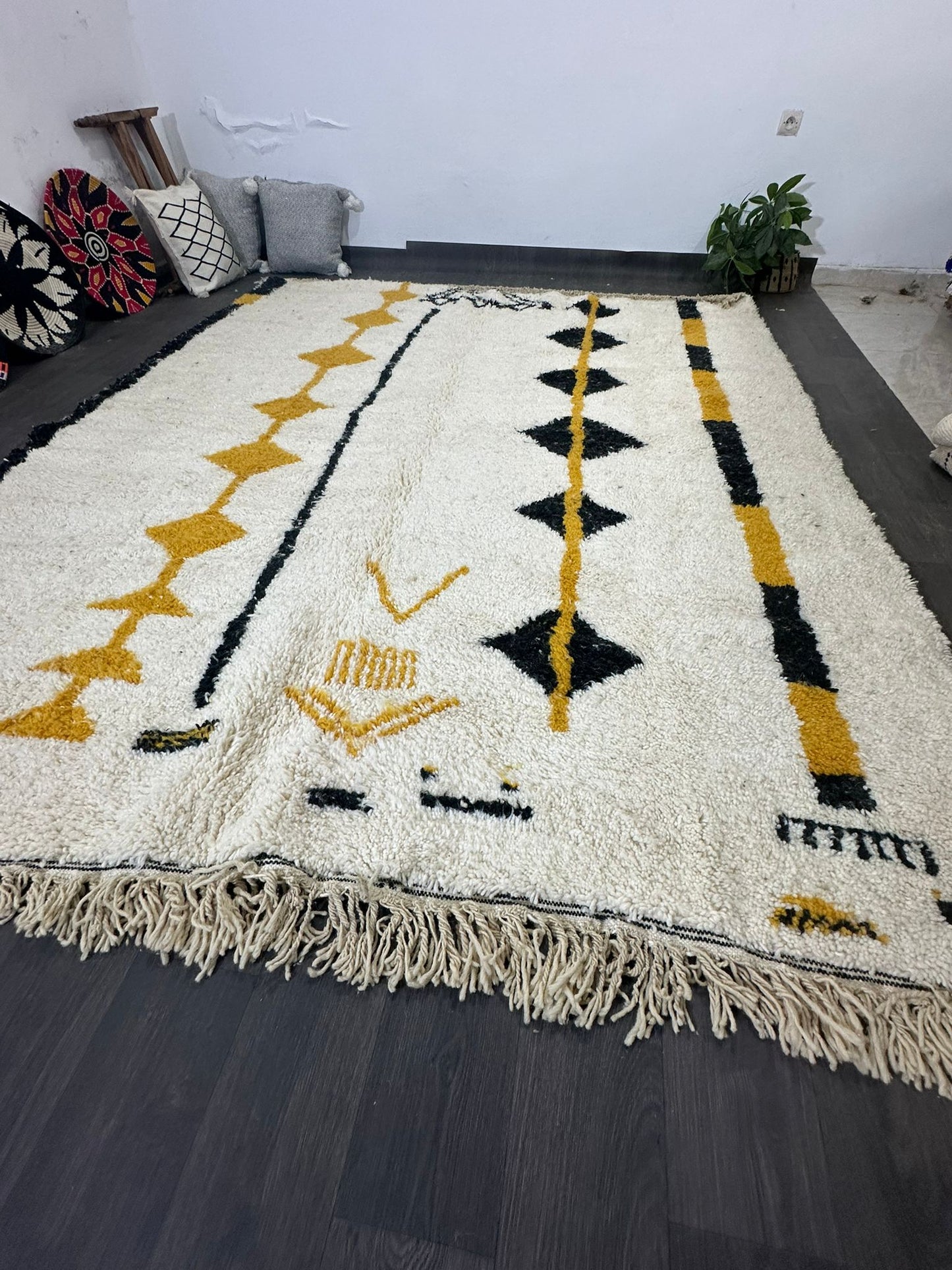 Amal is an off white Moroccan wool rug with black and mustard coloured lines and diamonds in the tribal design.