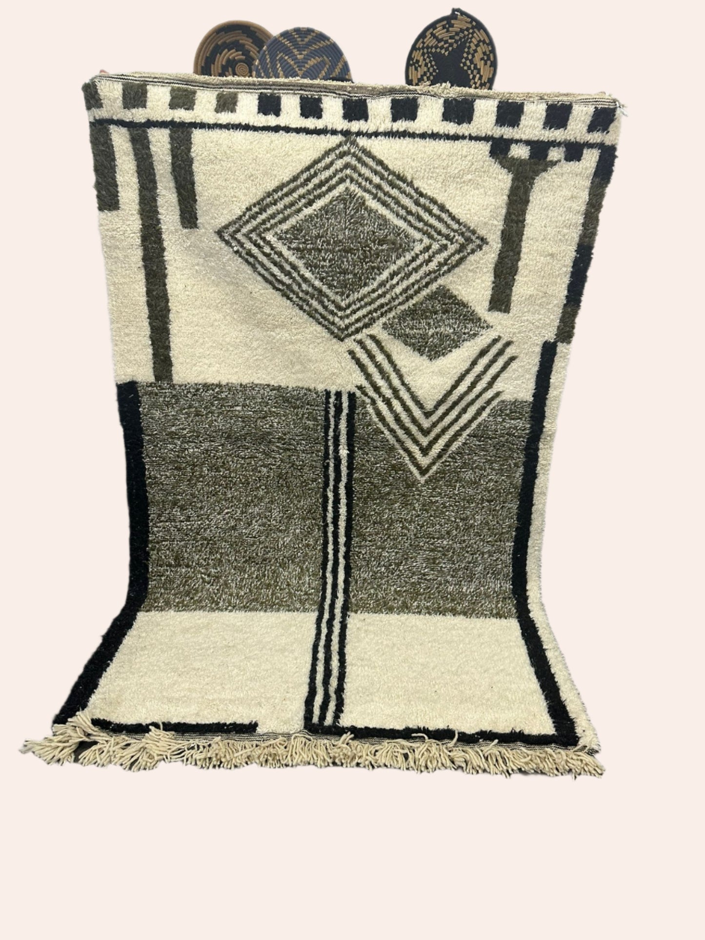 Geometric patterned rug on a wooden floor with a white wall background