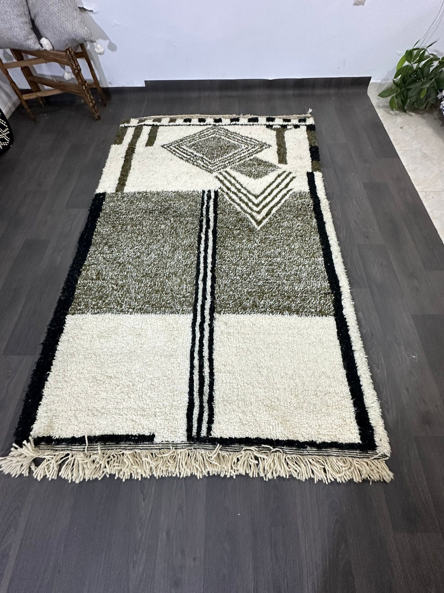 Geometric patterned Moroccan rug on a dark wooden floor