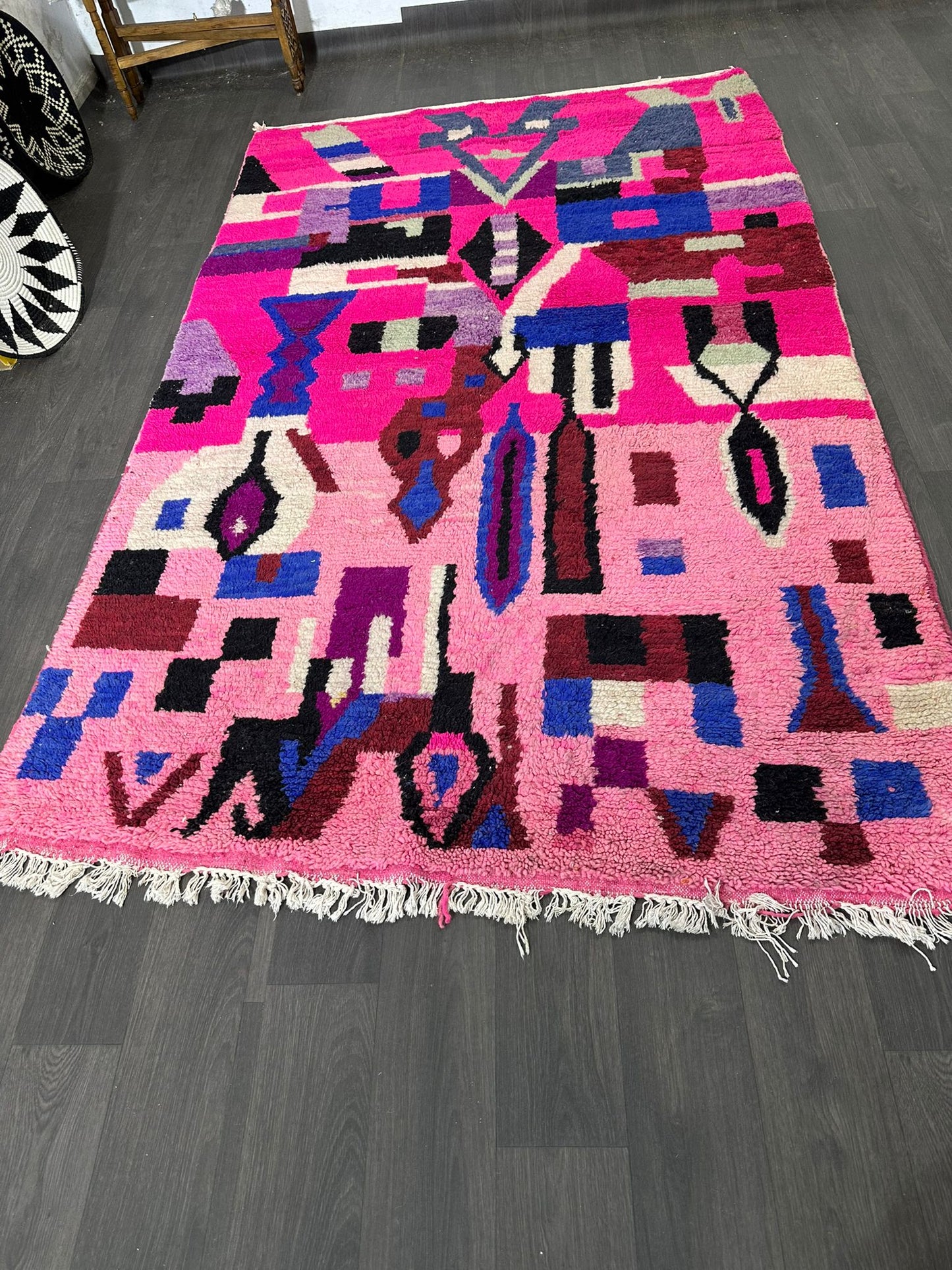 Colorful geometric-patterned rug on a dark wooden floor