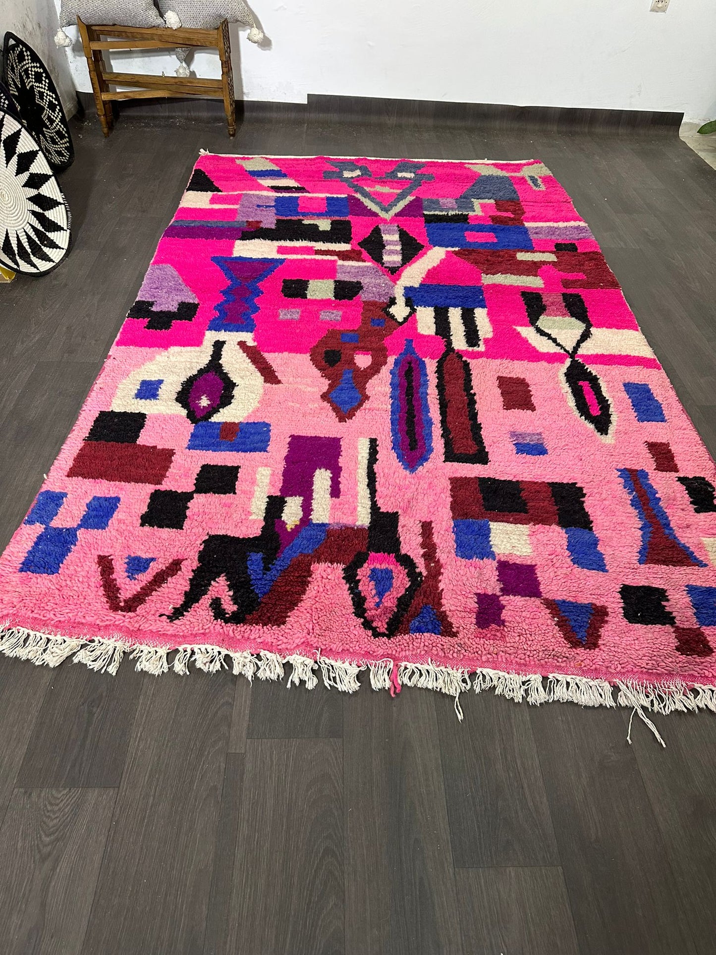 Colorful geometric-patterned rug on a wooden floor