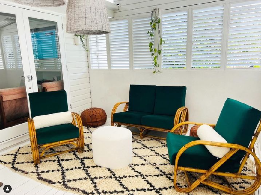 picture of vintage rug in white home with vintage green cane chairs
