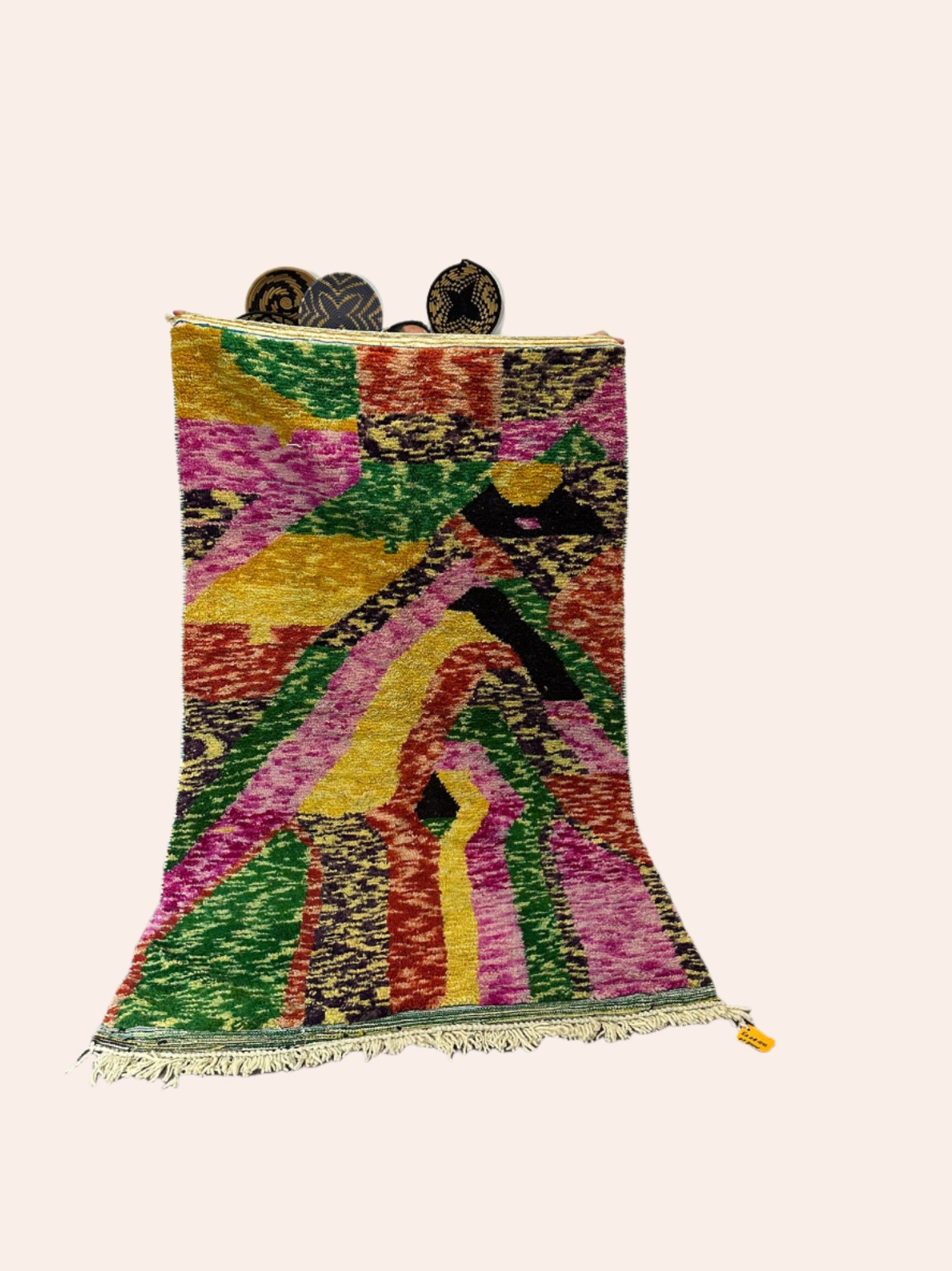 Colorful patterned rug on a wooden floor with a white wall background