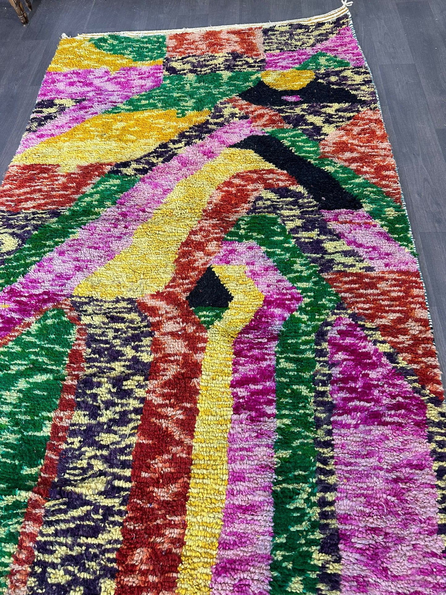 Colorful abstract patterned rug on a wooden floor