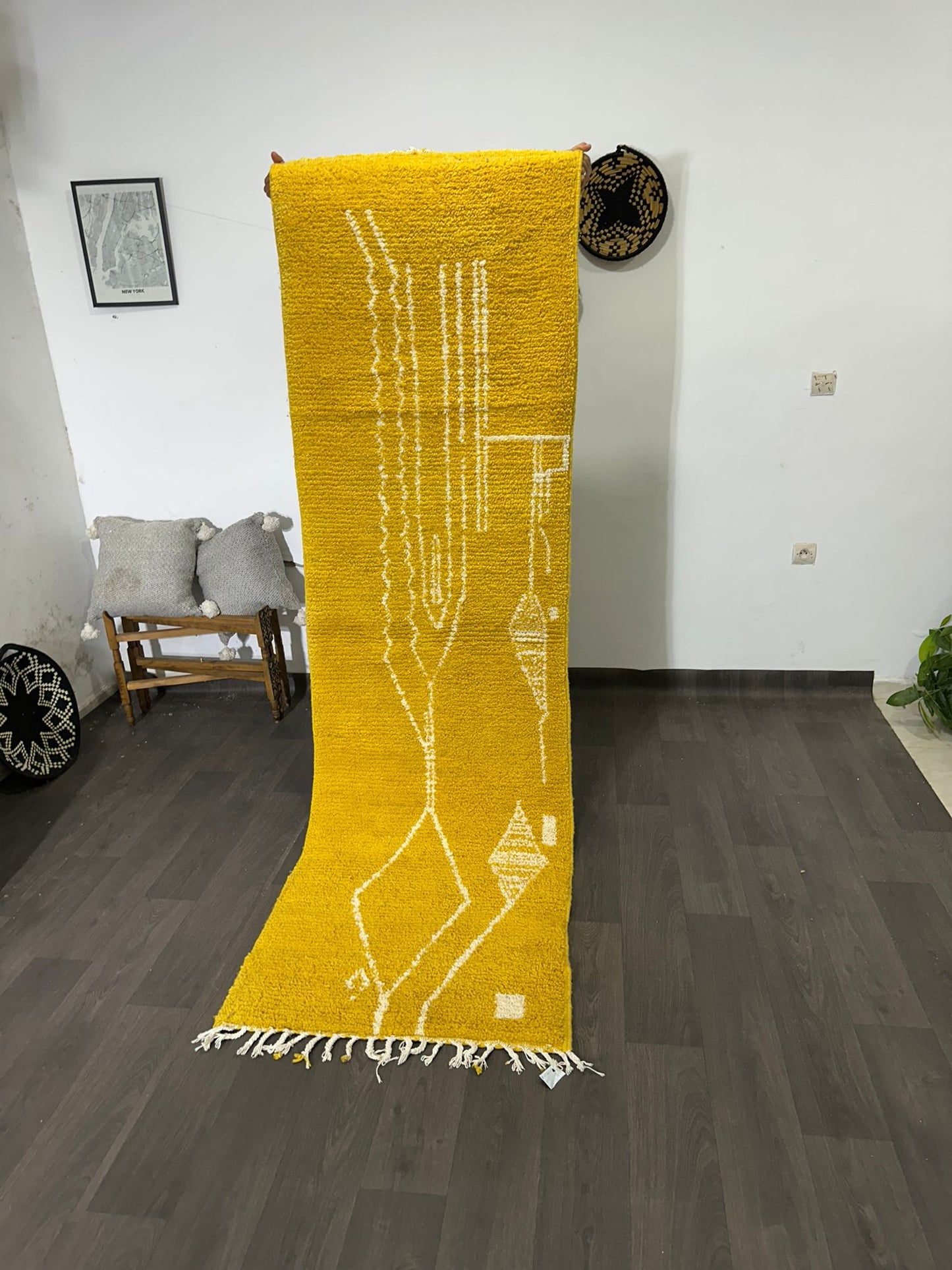 Yellow rug with white patterns on a wooden floor in a room.