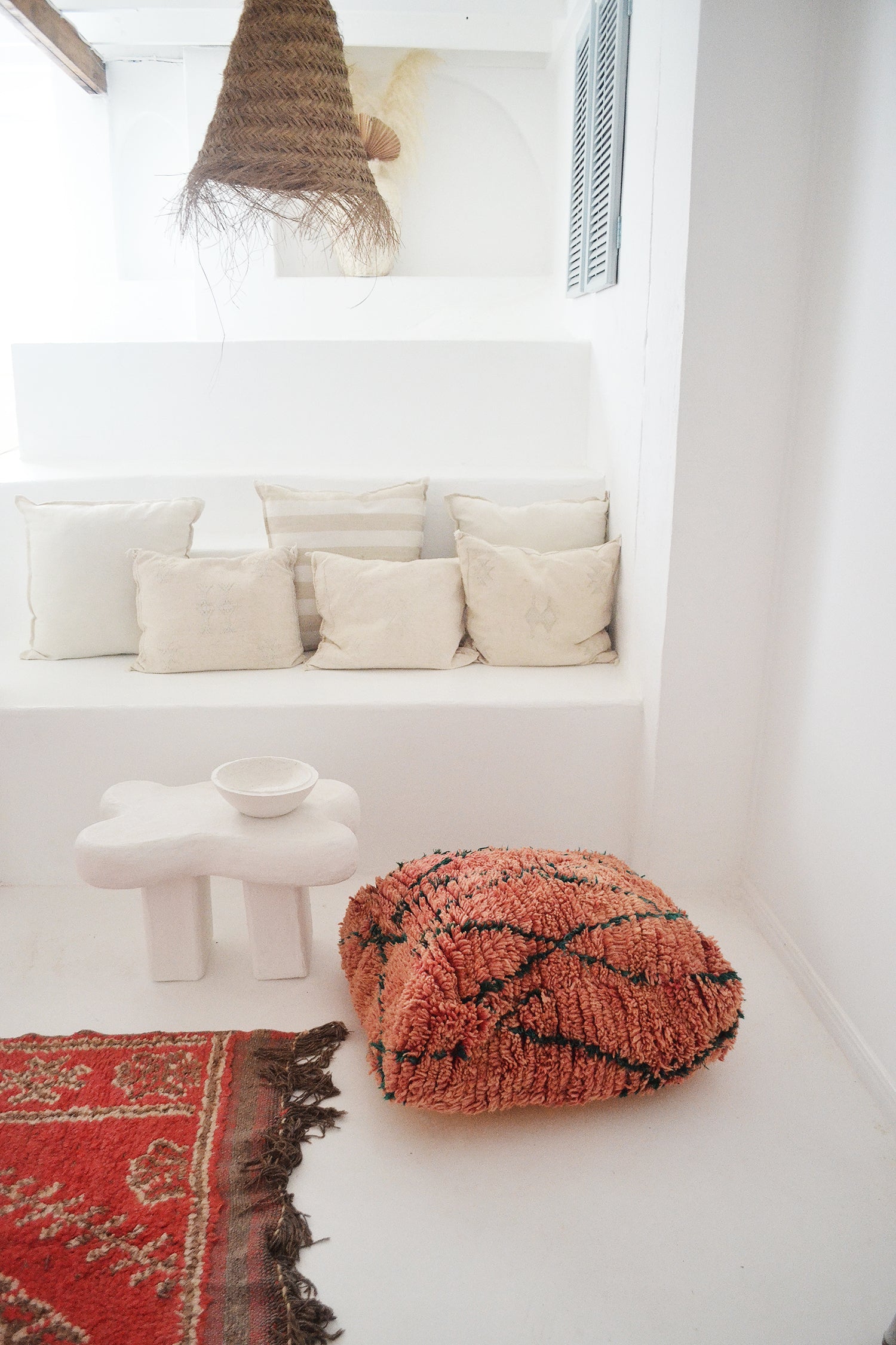 red floor cushion in a white room