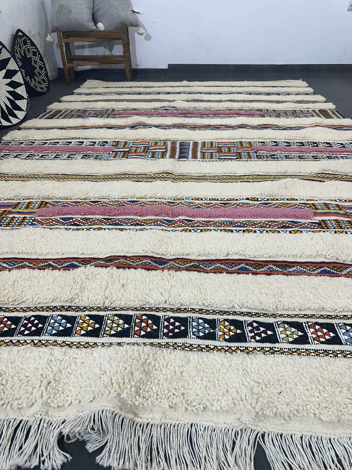 Striped patterned rug with fringes on a plain background
