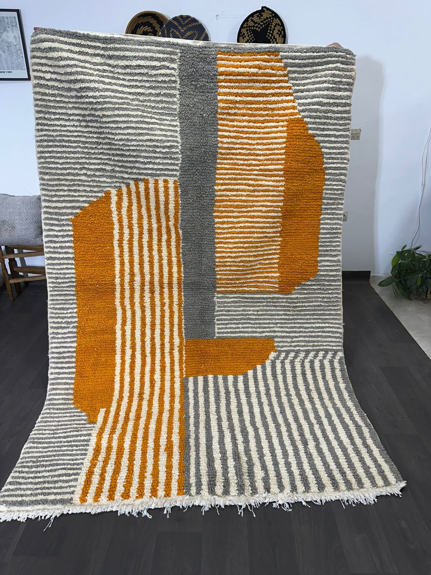Textured rug with orange and gray pattern on a dark floor.