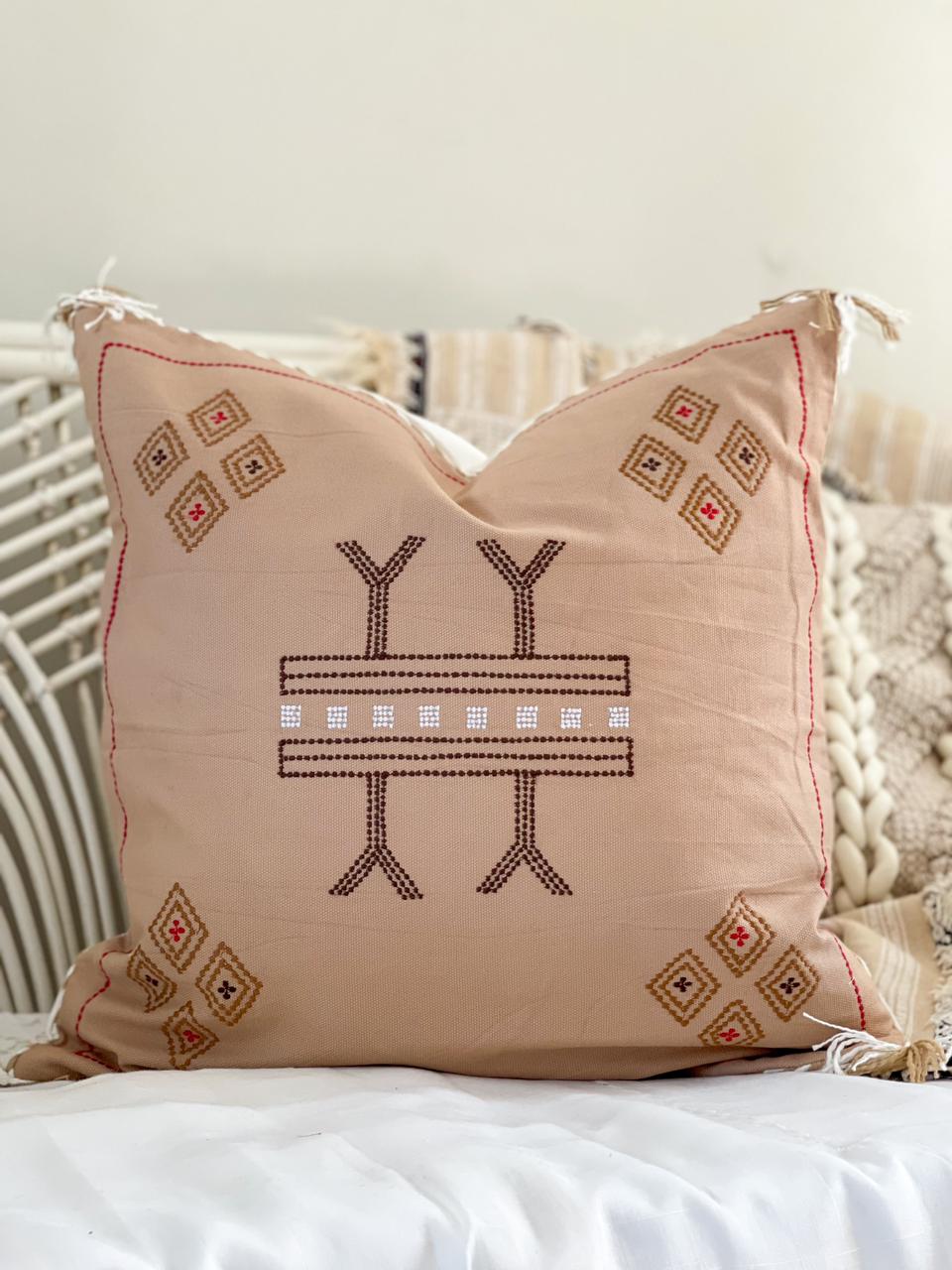 beige cotton cushion with embroidered detail