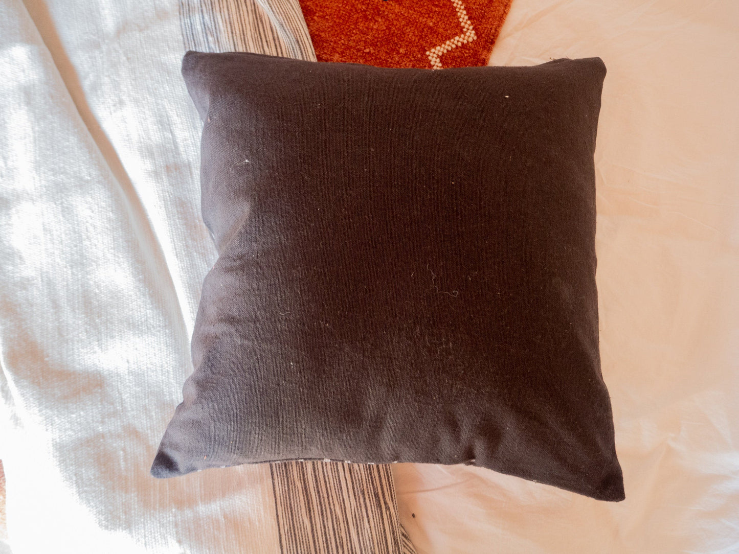 the back view of the cushion cover. It is plain black cotton fabric