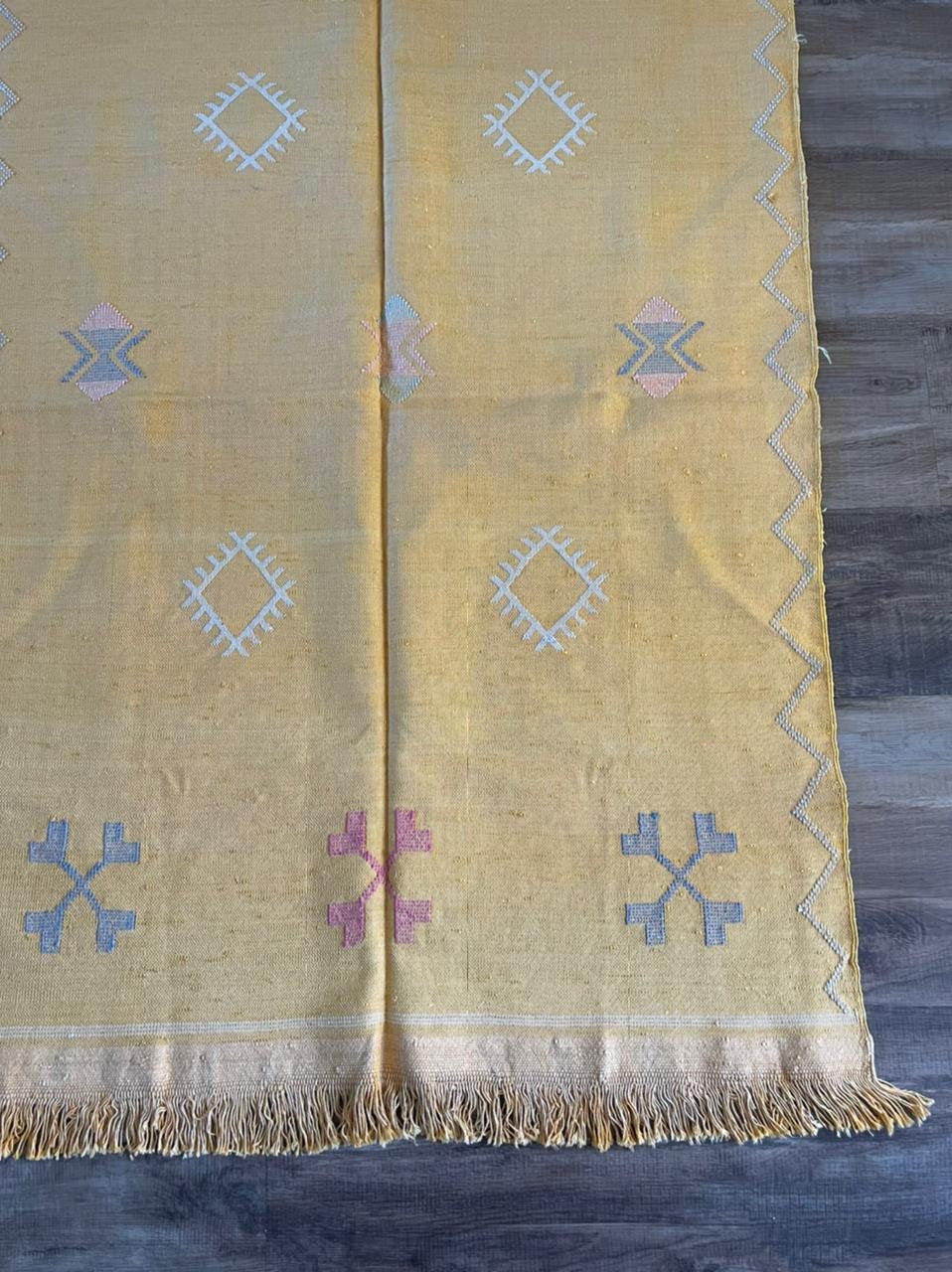 Yellow cactus silk rug with mutli coloured symbols woven into it