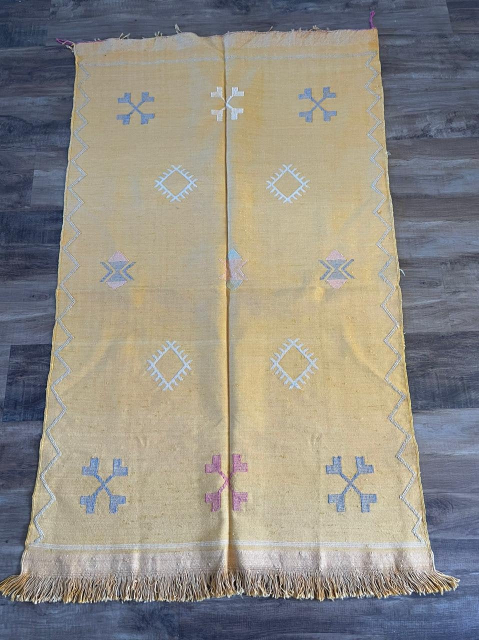 Yellow cactus silk rug with mutli coloured symbols woven into it
