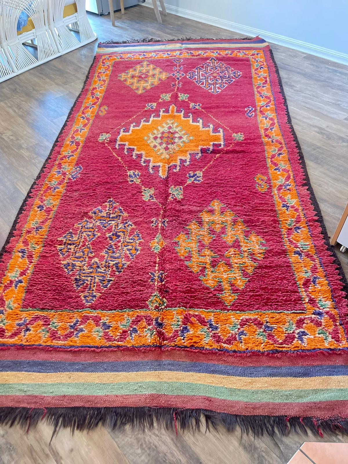 Vibrant red Moroccan Vintage rug with orange and blue/purple accents and symbols