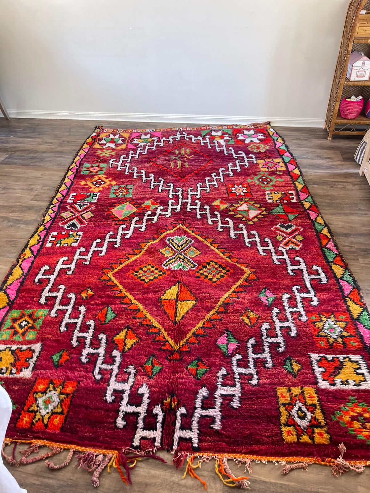 Red/purple vintage Moroccan Boujaad rug with orange, yellow, pink, red and green accents