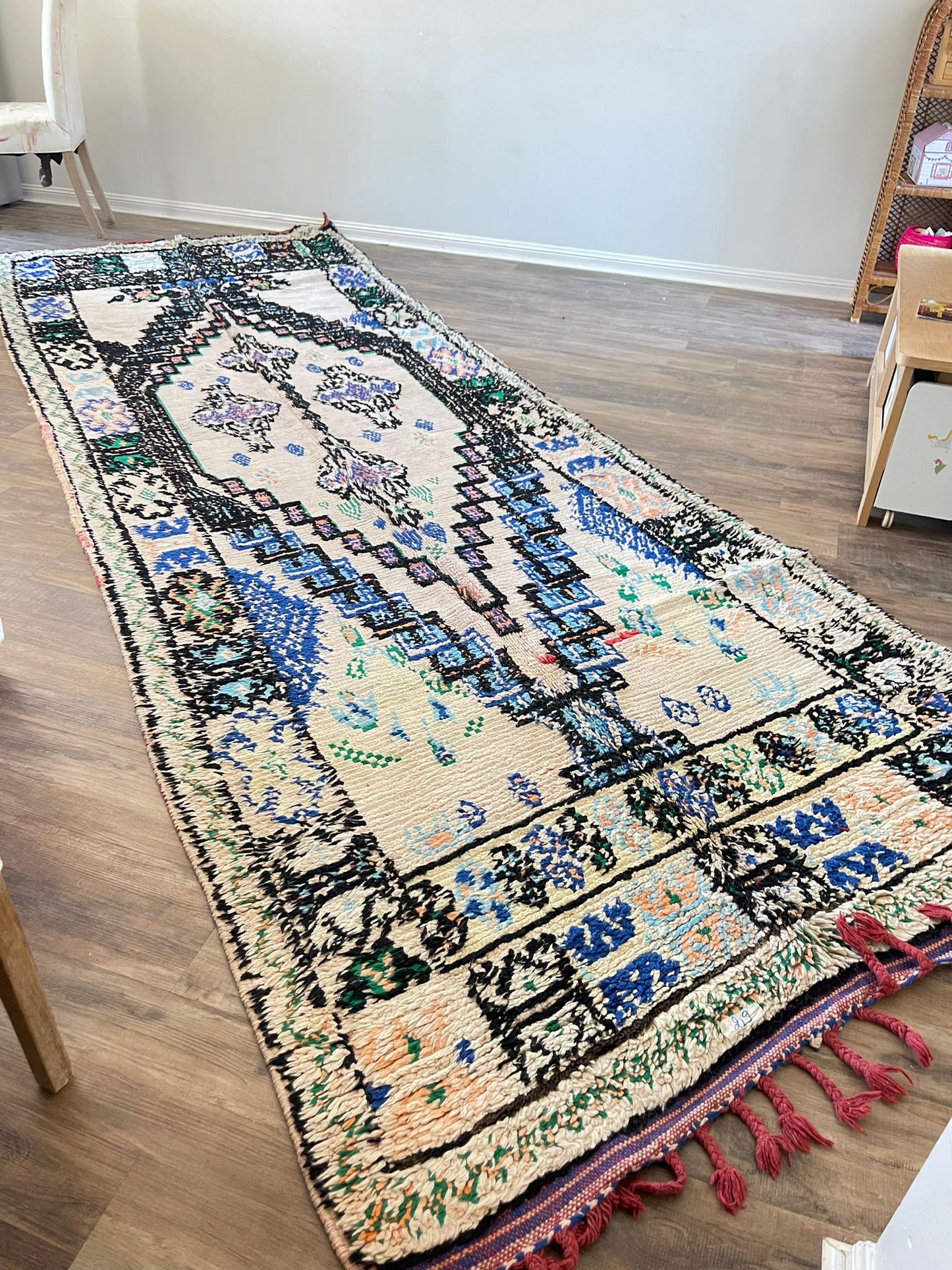 cream coloured Vintage Moroccan boujaad rug with blue, green and light orange symbols and patterns