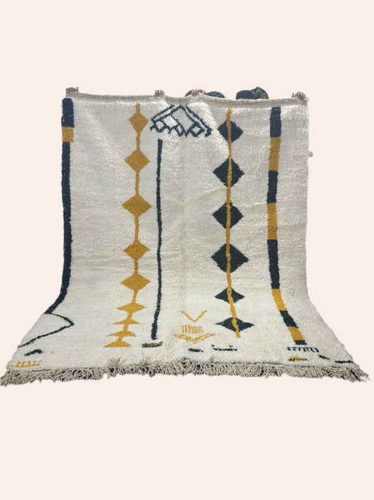 Amal is an off white Moroccan wool rug with black and mustard coloured lines and diamonds in the tribal design. 