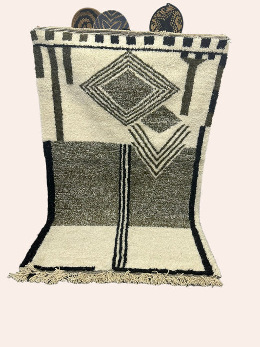 Geometric patterned rug on a wooden floor with a white wall background