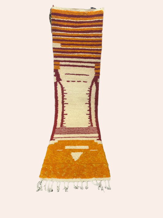 Long, colorful  Moroccan wool runner rug with striped pattern on a wooden floor.