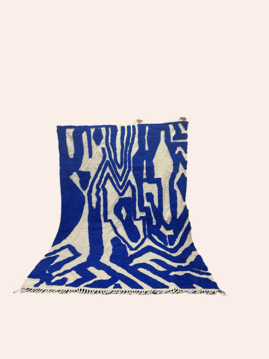 Marjorelle blue and off-white Moroccan Wool rug being held up