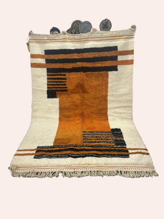 Zagora is an off-white Moroccan wool rug with black and orange/brown shapes and lines in the design. it