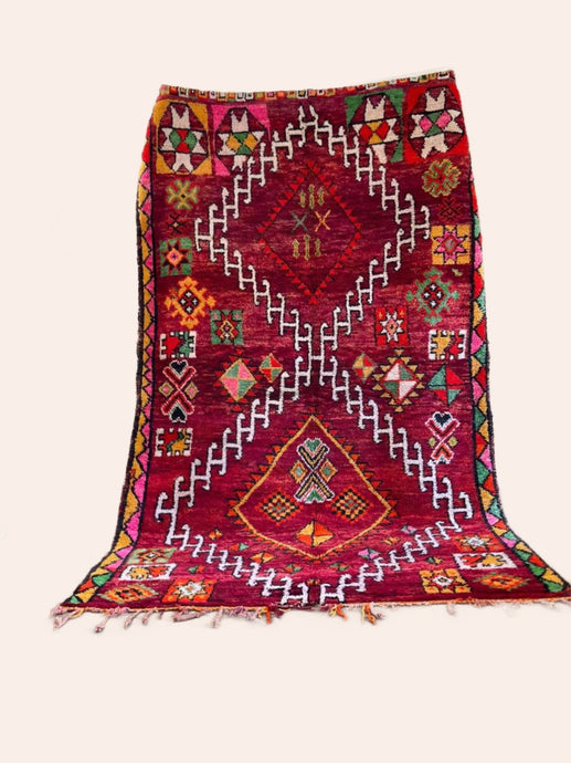 Red/purple vintage Moroccan Boujaad rug with orange, yellow, pink, red and green accents