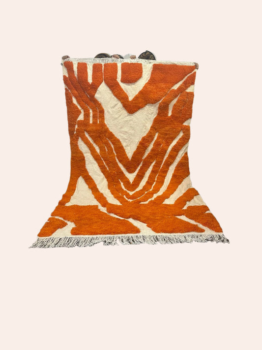 contemporary orange and off-white Moroccan wool rug being held up
