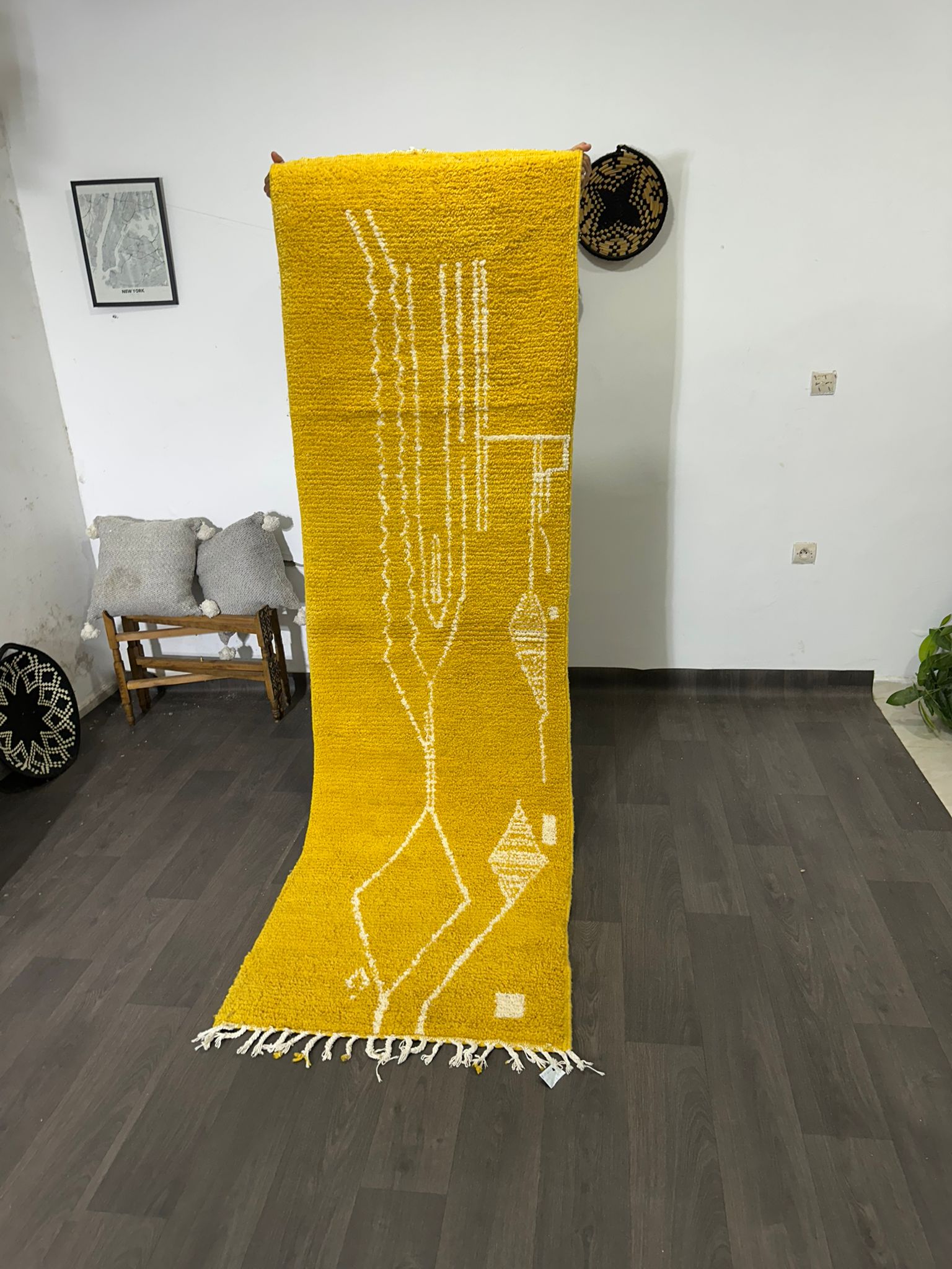 Yellow rug with white patterns on a wooden floor in a room.