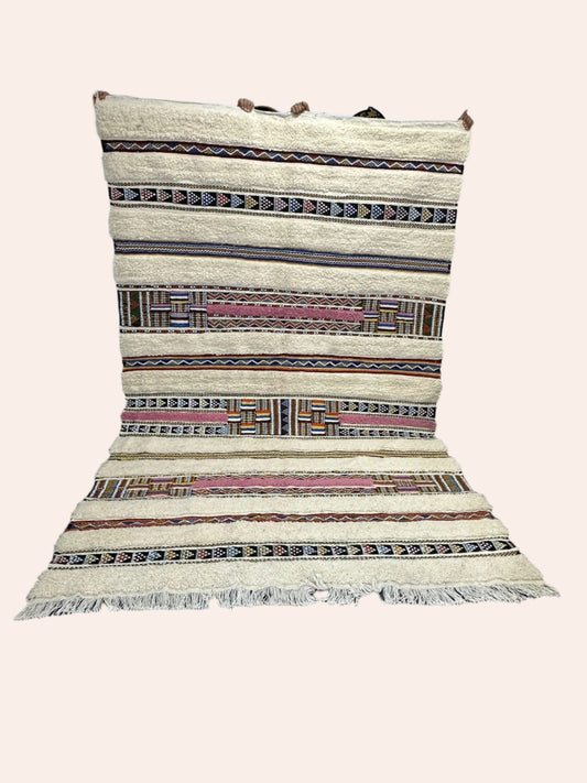 Woven rug with geometric pattern on a wooden floor