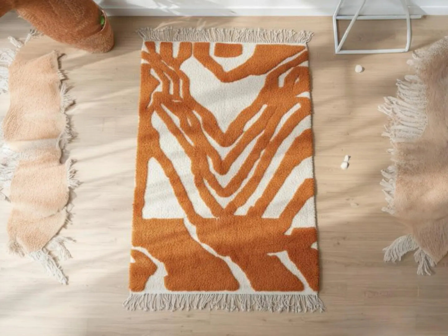 Orange and white patterned rug on a wooden floor