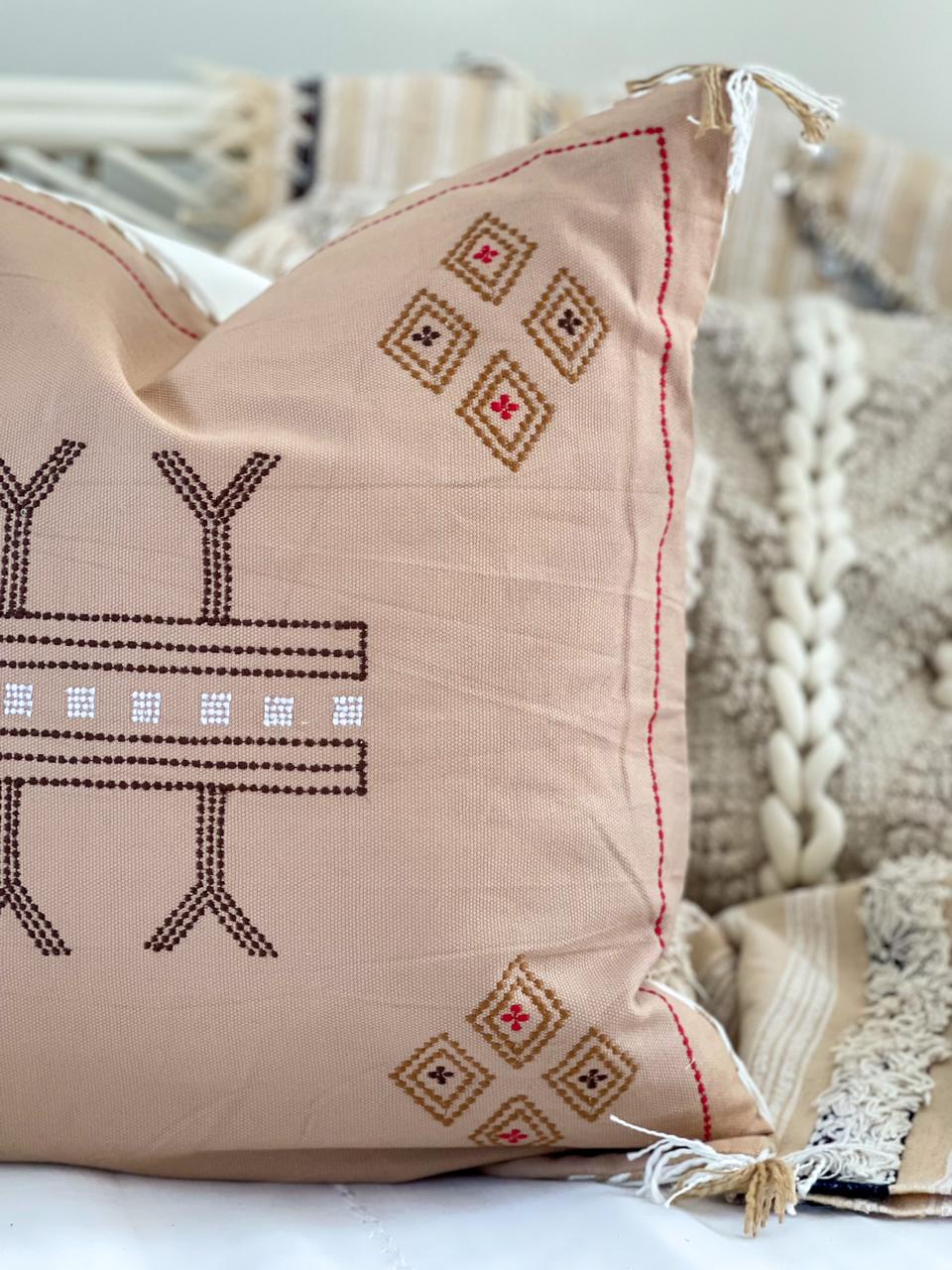 beige cotton cushion with embroidered detail