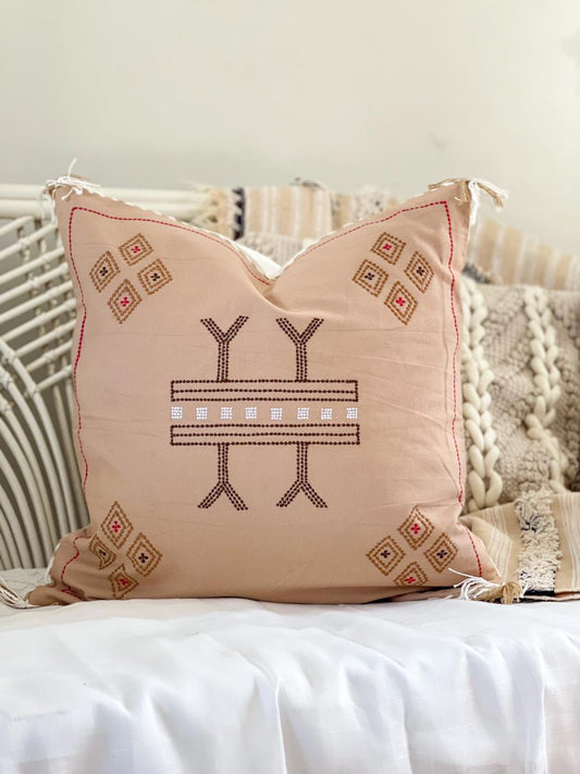 beige cotton cushion with embroidered detail